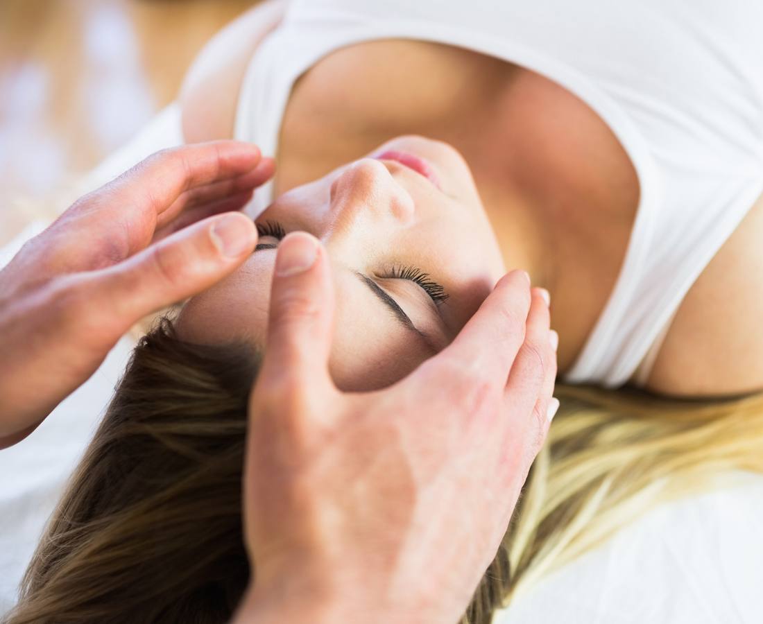 Entspannte Frau während einer Reiki-Anwendung